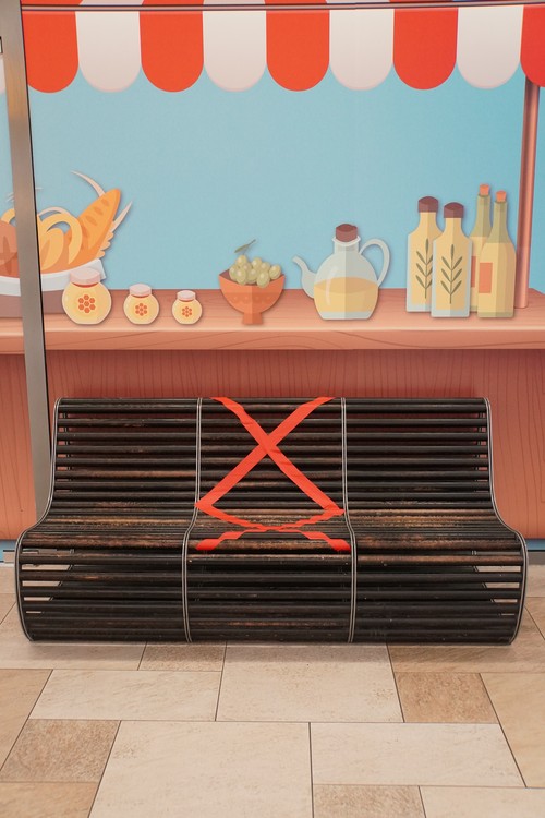Abgesperrter Sitzbank-Teil in Einkaufspassage. X-Kreuz