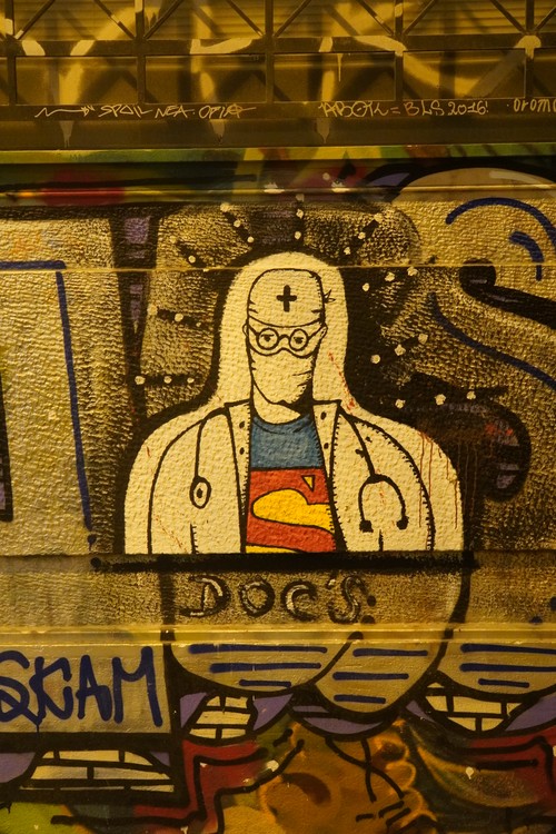 Graffiti. Arzt mit Maske und Superman-Logo