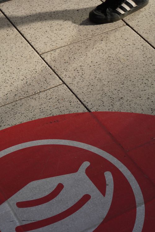 Maskenpflicht Bahn-Zeichen am Boden. Schuh. Hauptbahnhof