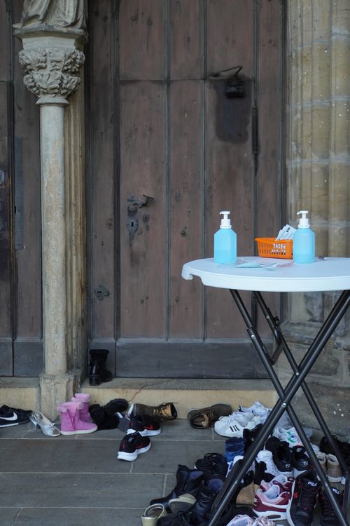 Kirche mit Desinfektionsstand, Registrierung. Schuhe. Tür