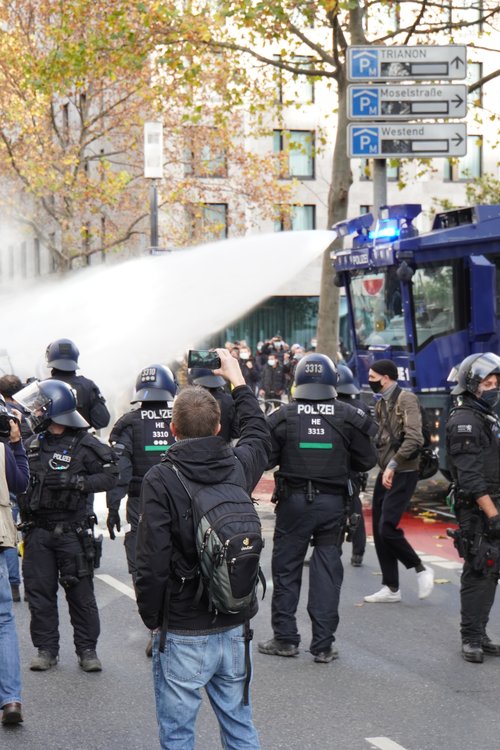 Polizei-Wasserwerfer bei Antifa Querdenken-Gegendemo. Handy