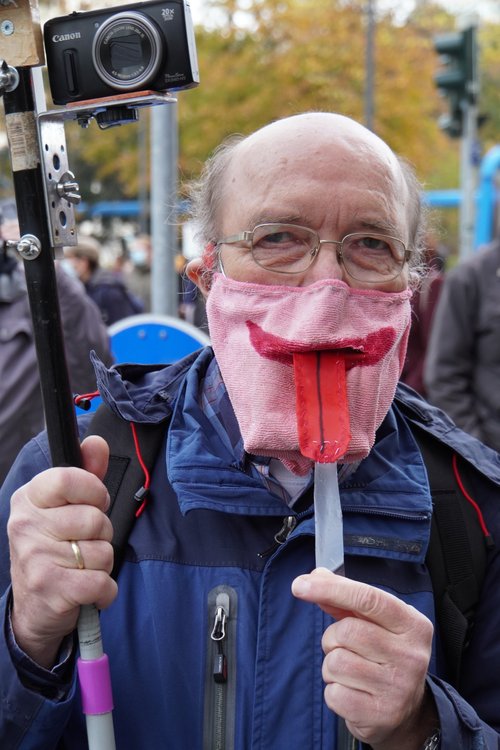 Querdenken-Gegendemo. Zungenmaske. Canon-Kamera